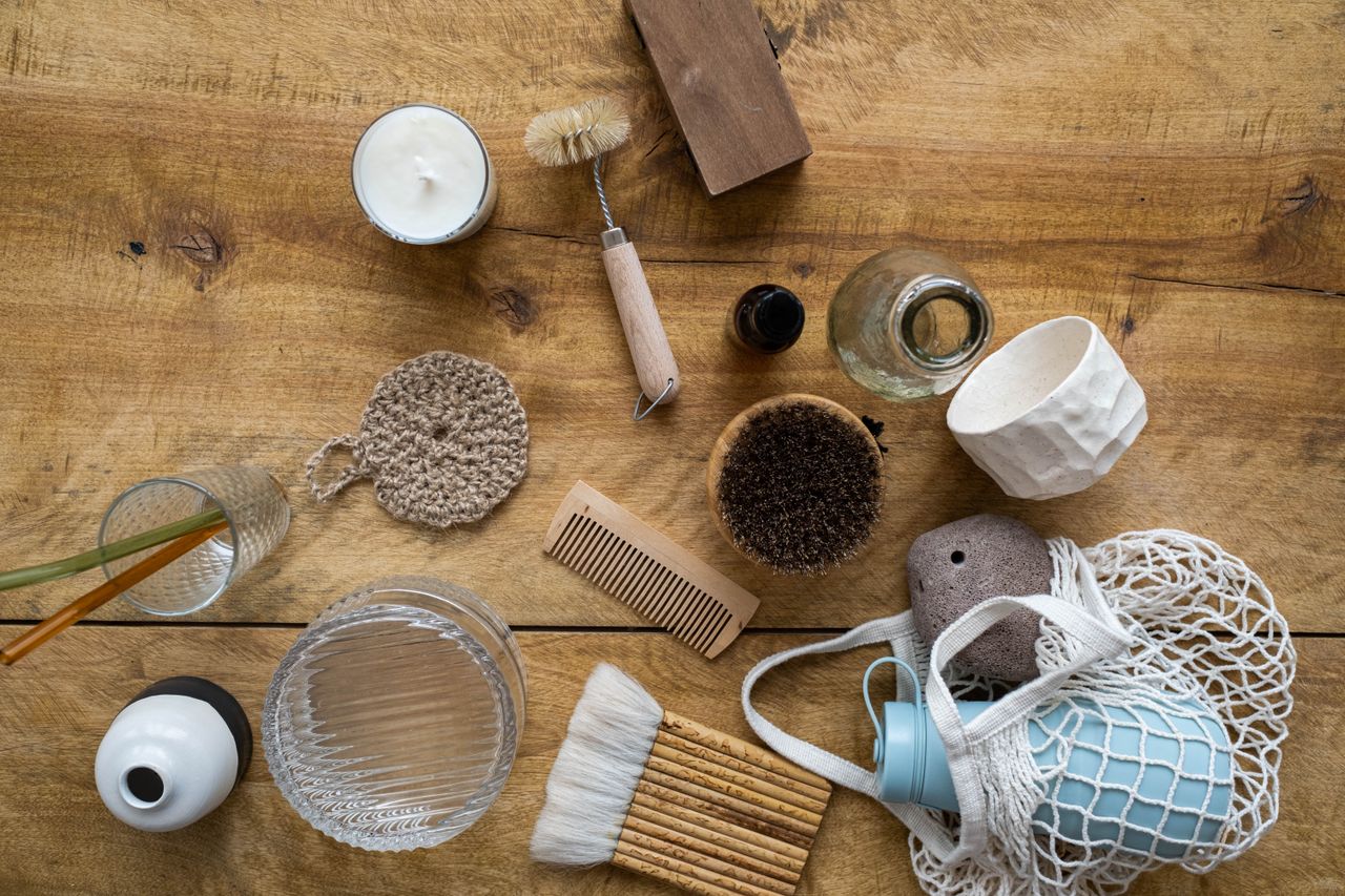 Flat lay of various eco-friendly household items on a wooden surface for a sustainable lifestyle.