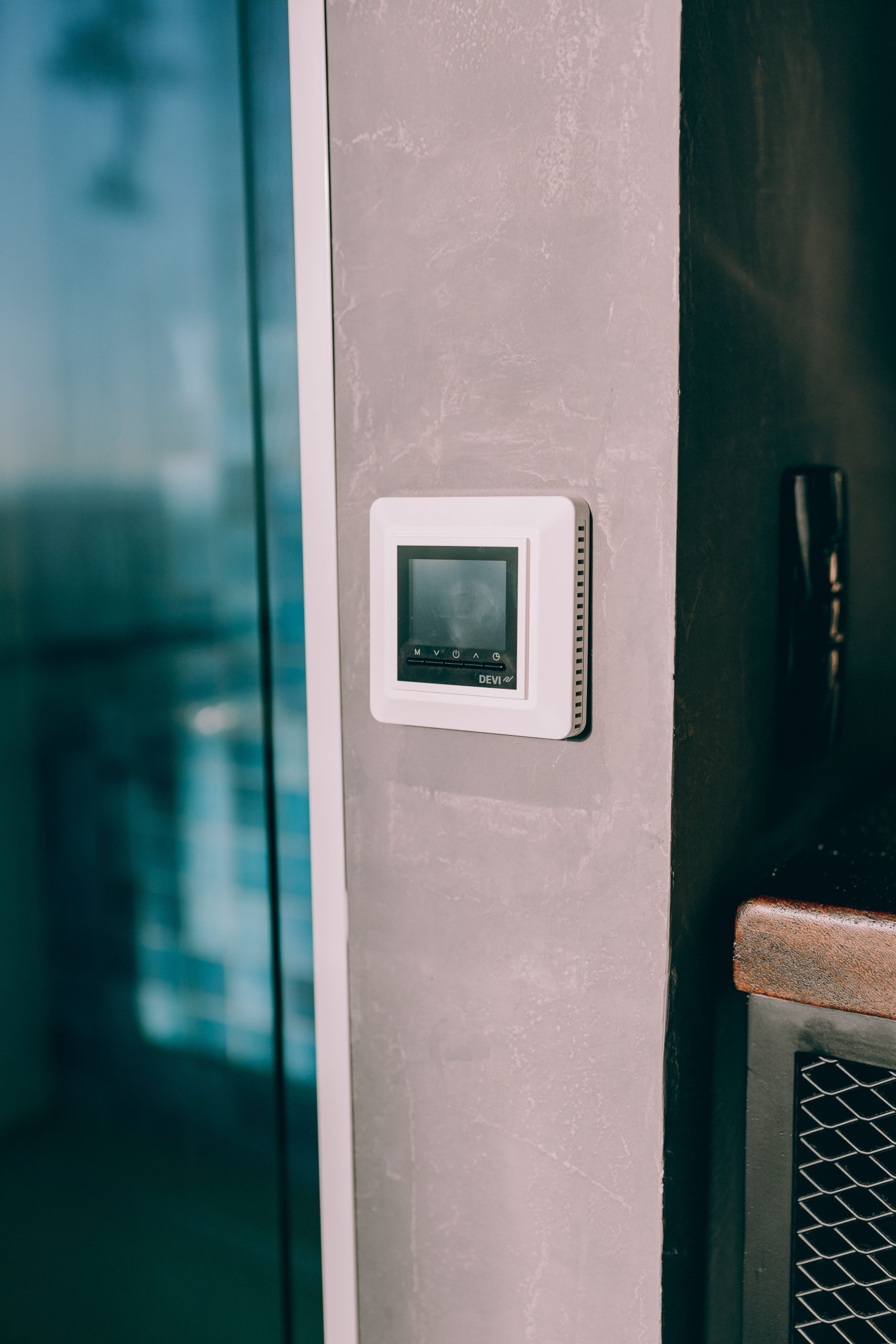 Smart thermostat mounted on a wall next to a window