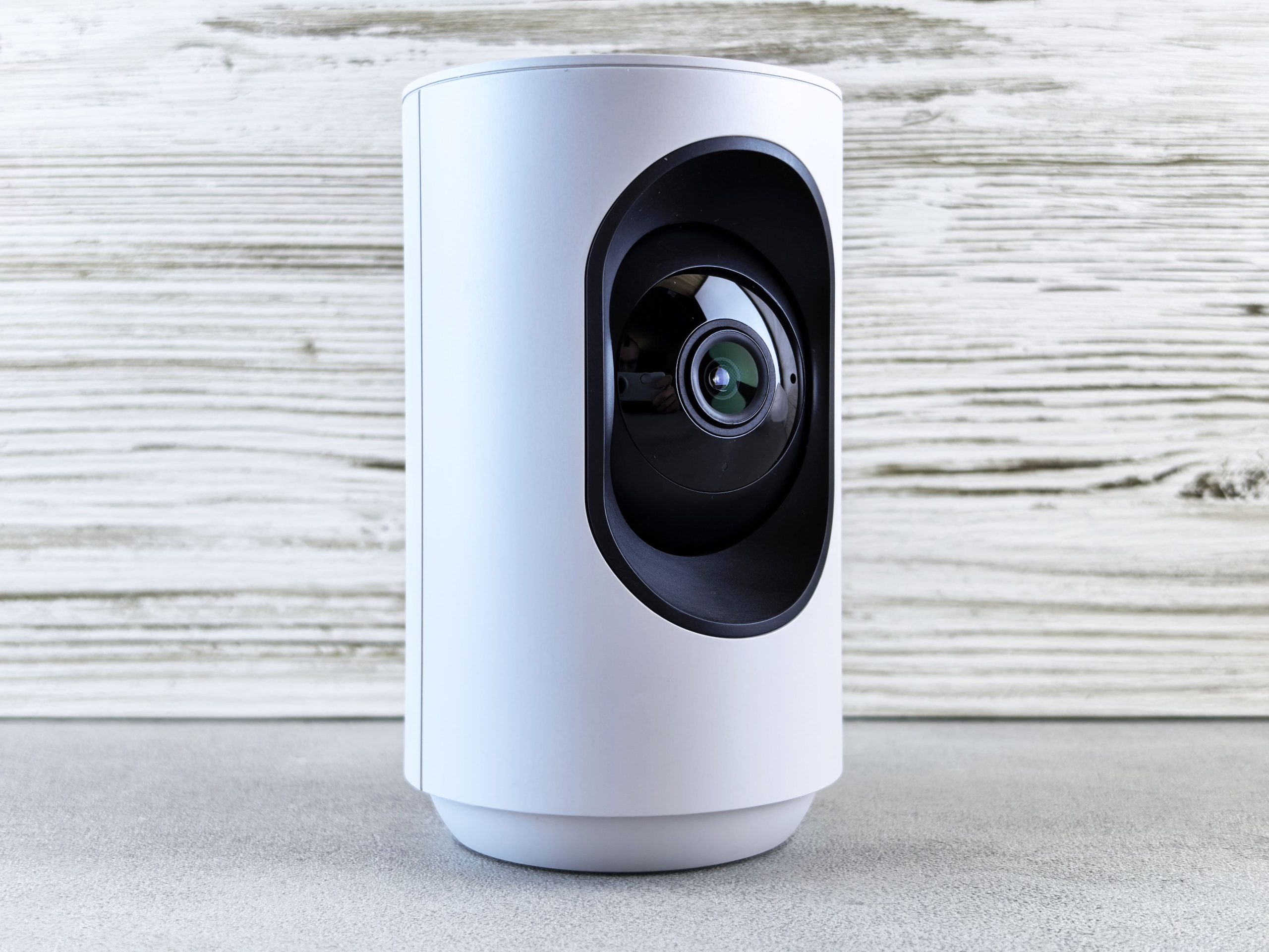 White indoor security camera on a wooden surface