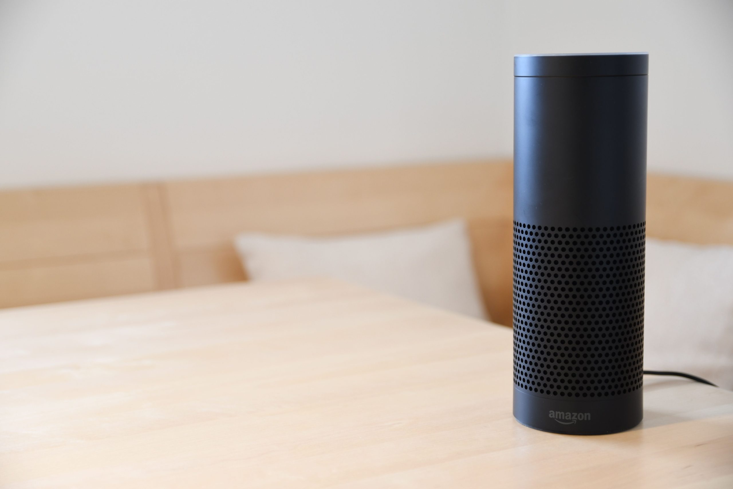 Black Amazon Echo smart speaker on a wooden table